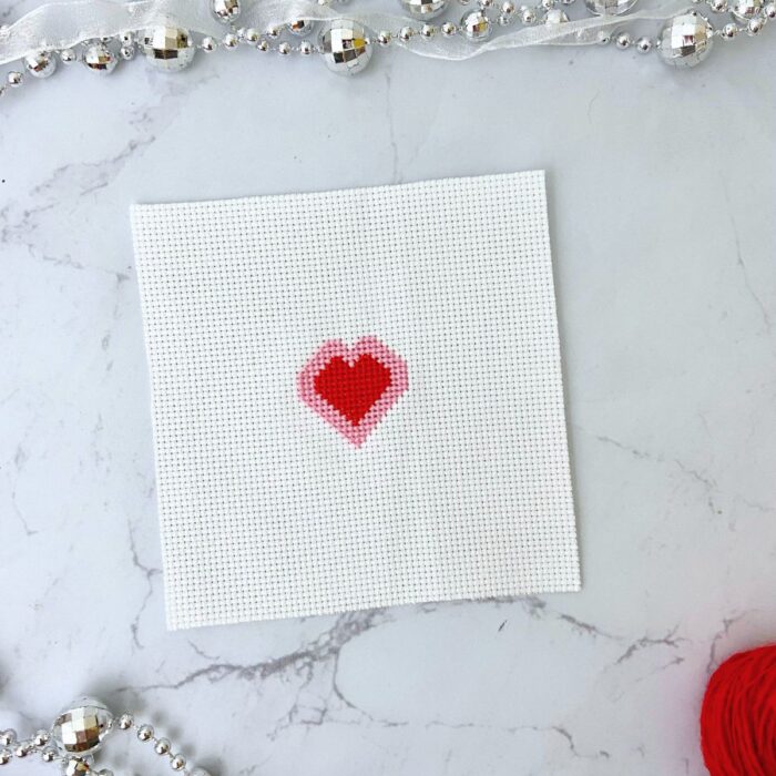 Red and pink cross stitched heart.