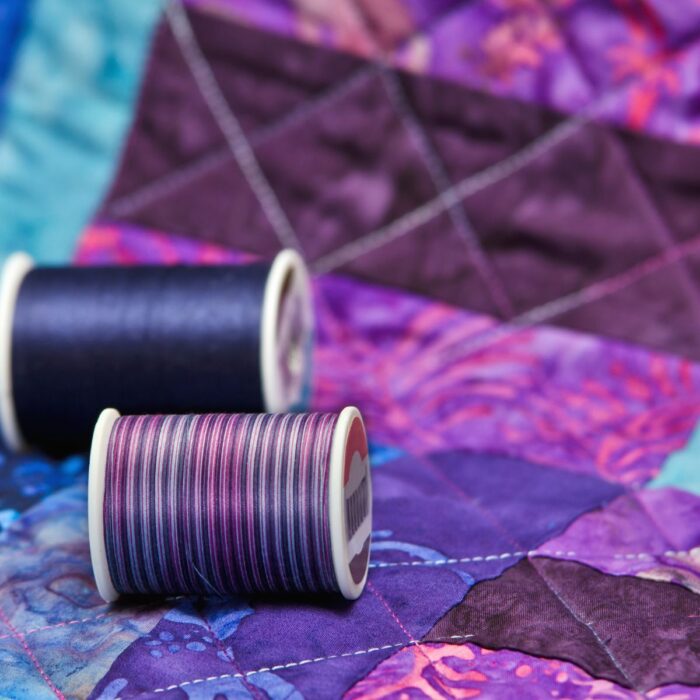 Purple and blue quilt and thread.